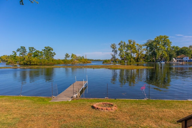 dock area with a yard, a water view, and a fire pit