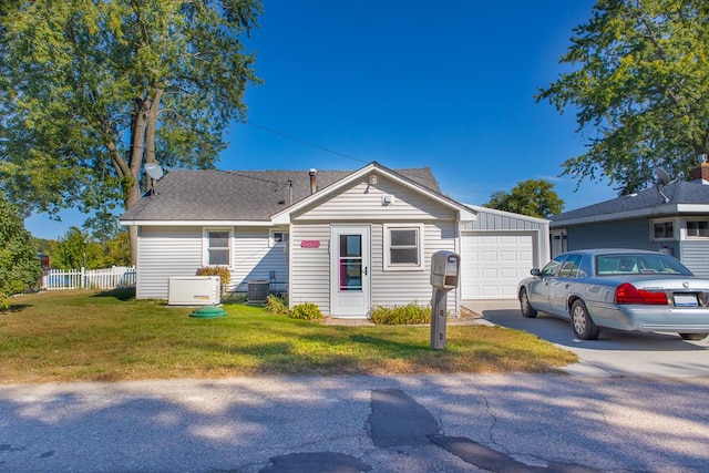 ranch-style house featuring cooling unit, a front yard, and a garage