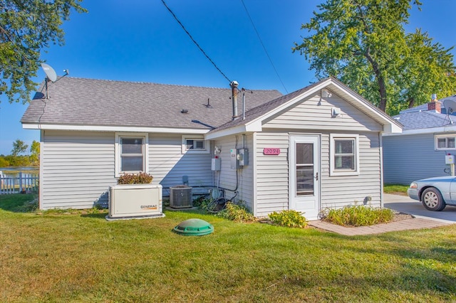 back of house featuring a lawn and cooling unit