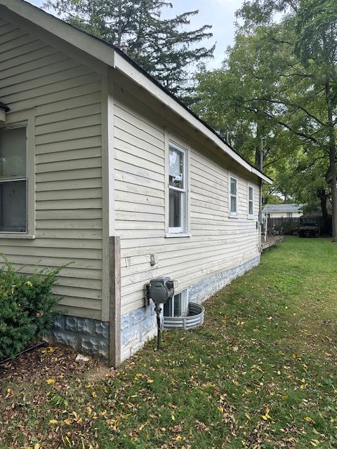 view of property exterior with a lawn