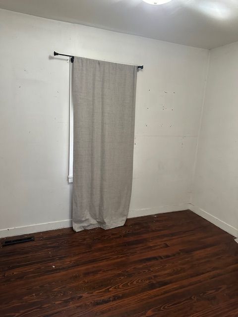 empty room with dark hardwood / wood-style floors