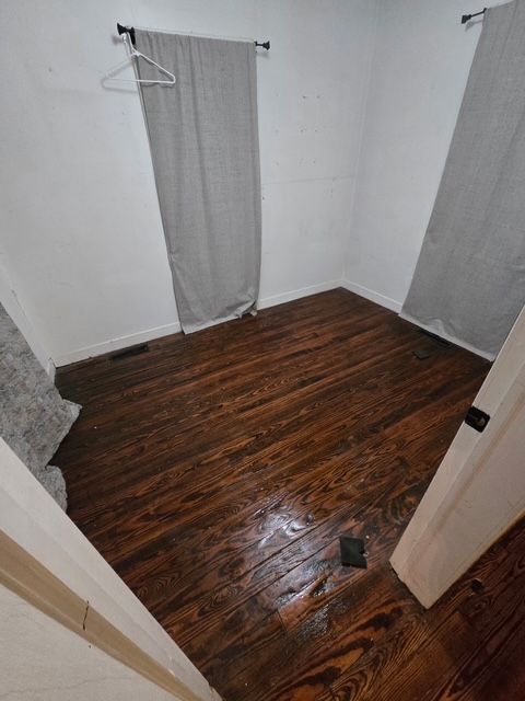 empty room with dark hardwood / wood-style flooring