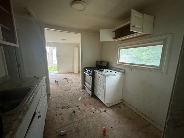 kitchen with white cabinets, sink, and gas range