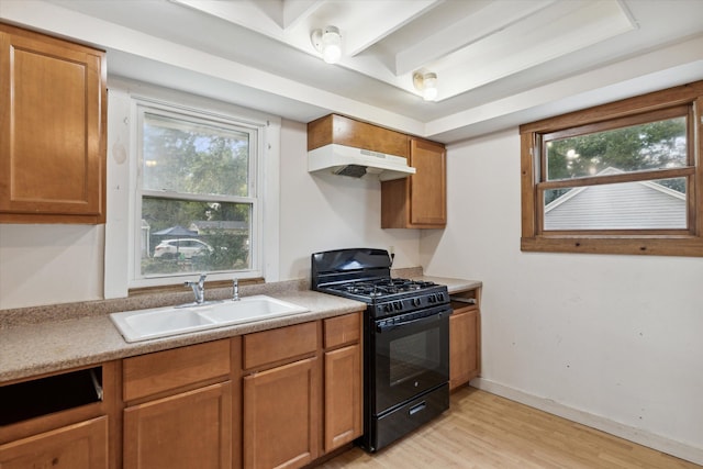 kitchen featuring sink, light wood-type flooring, exhaust hood, and gas stove