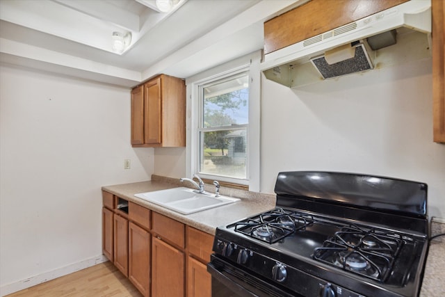 kitchen with sink, light hardwood / wood-style floors, ventilation hood, and black gas range