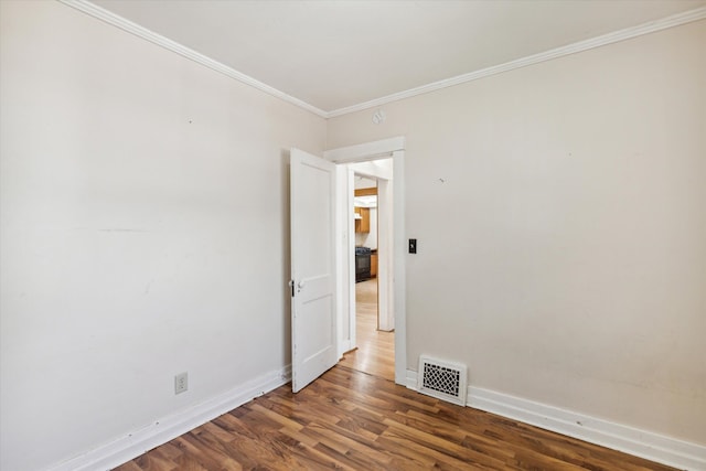 empty room with dark wood-type flooring and ornamental molding