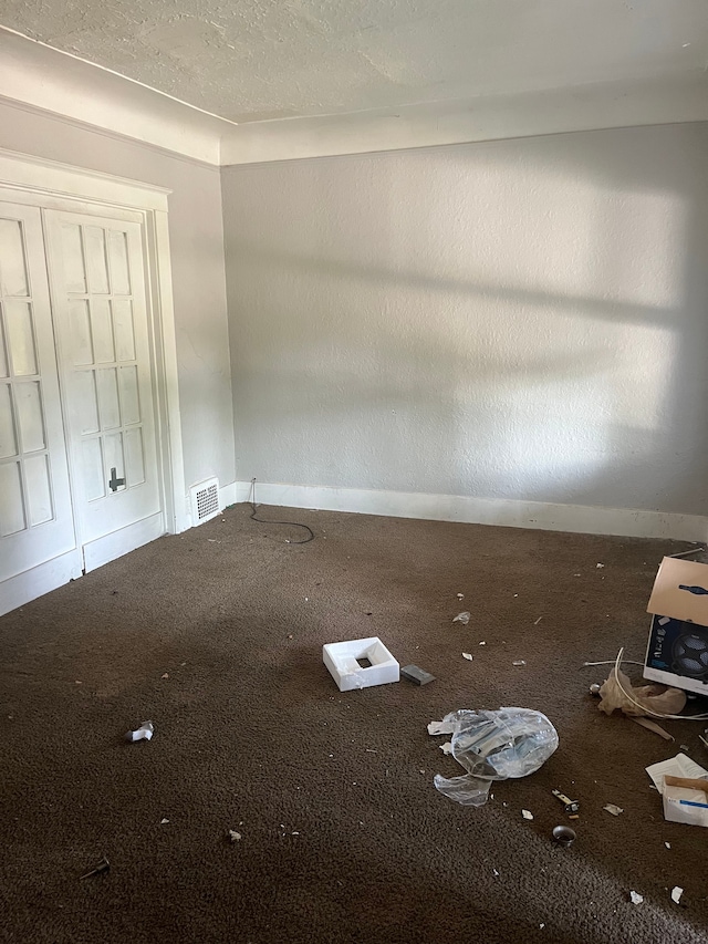 unfurnished bedroom with carpet flooring, a textured ceiling, and a closet