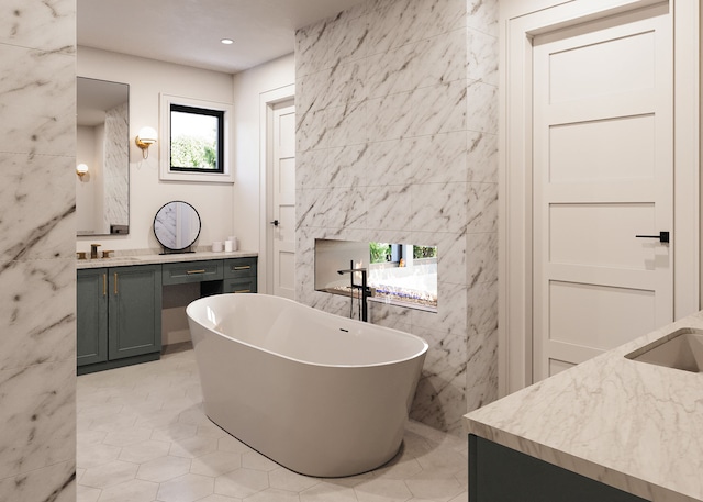 bathroom with tile patterned flooring, a washtub, tile walls, and vanity