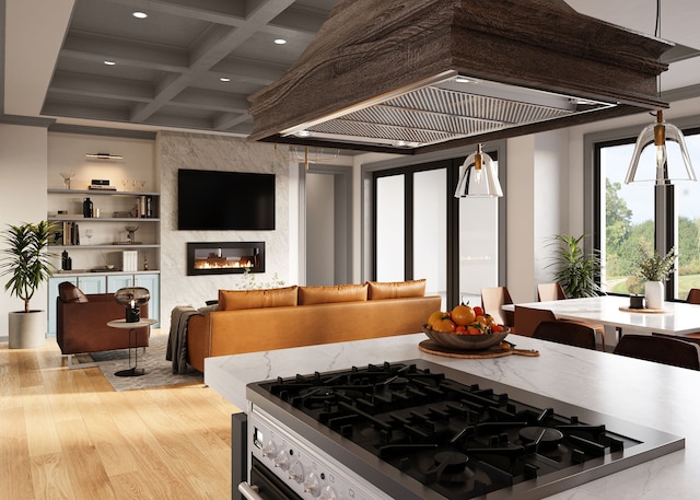 kitchen featuring a high end fireplace, coffered ceiling, hanging light fixtures, light hardwood / wood-style flooring, and beam ceiling