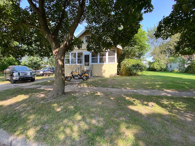 view of front of property with a sunroom and a front lawn