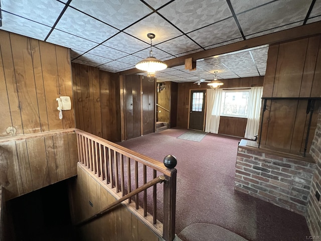 interior space featuring carpet and wooden walls