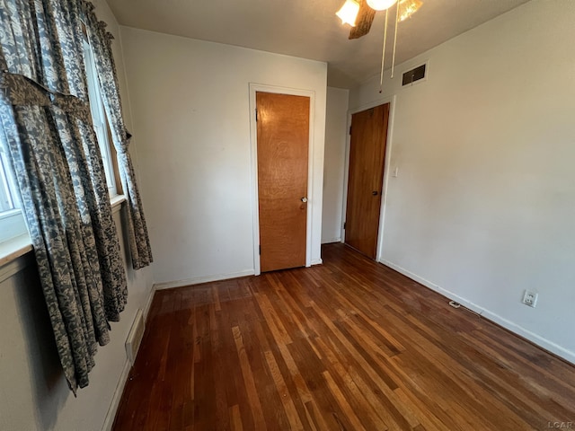 unfurnished bedroom with ceiling fan, a closet, and dark hardwood / wood-style floors