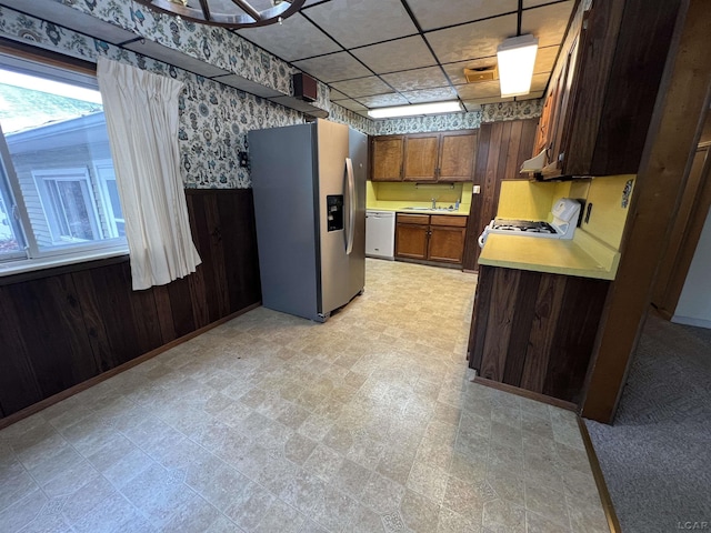 kitchen with stainless steel fridge with ice dispenser, stove, white dishwasher, and decorative light fixtures