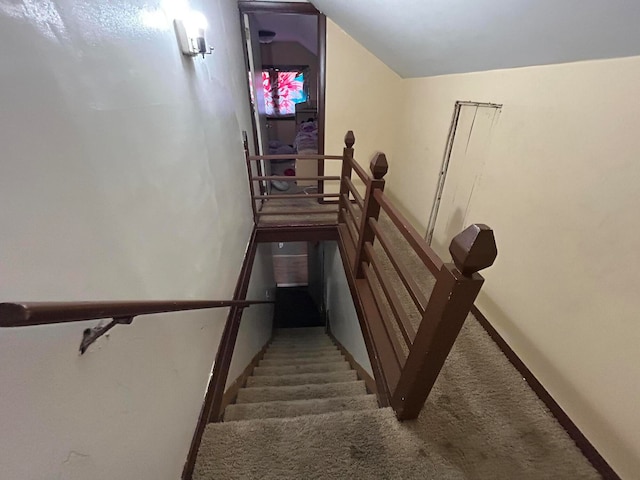 stairway with carpet and lofted ceiling