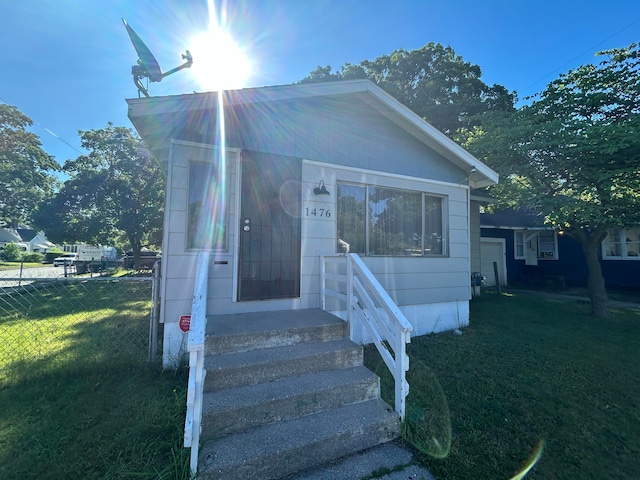 bungalow-style home with a front yard