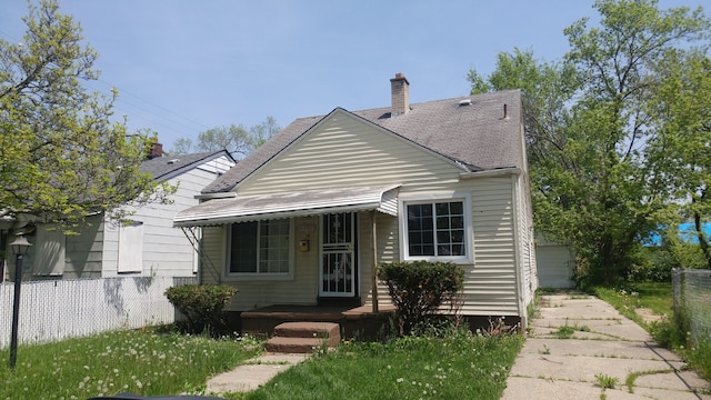 bungalow with a garage and an outbuilding