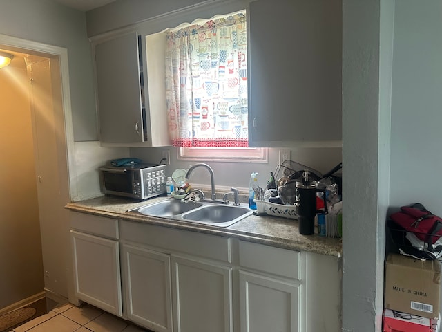 kitchen with sink, white cabinets, and light tile patterned floors