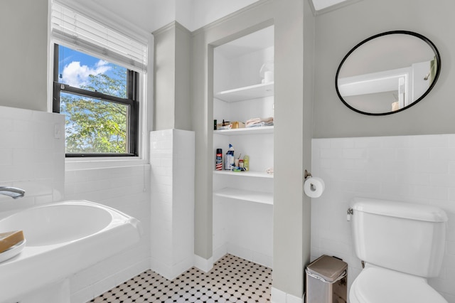 bathroom with sink, tile walls, and toilet