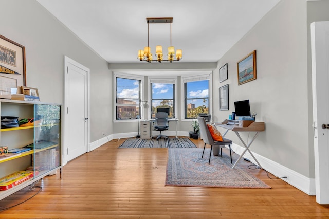 office area with light hardwood / wood-style flooring and a notable chandelier