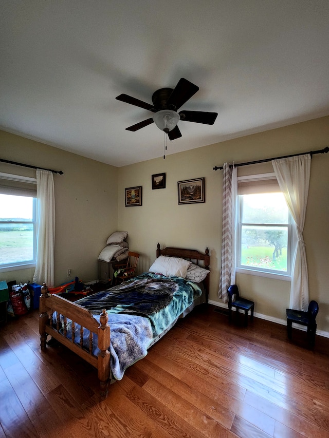 bedroom featuring multiple windows, ceiling fan, and wood-type flooring