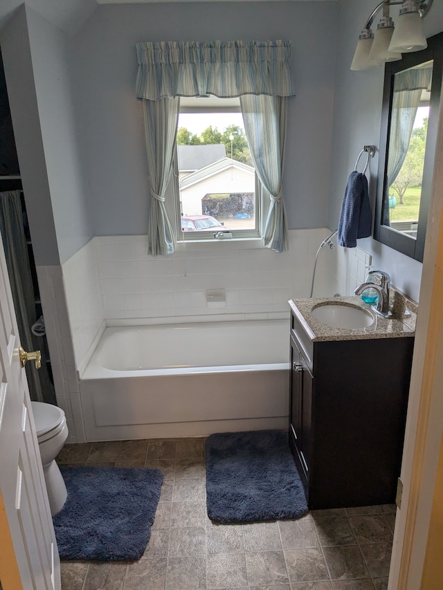 bathroom featuring a tub, vanity, and toilet