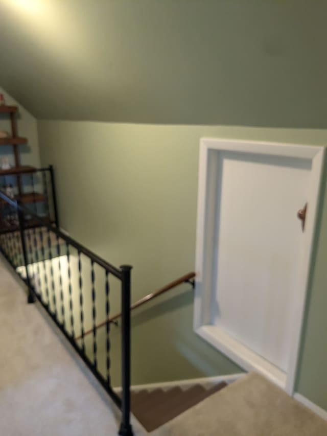 staircase with carpet and lofted ceiling