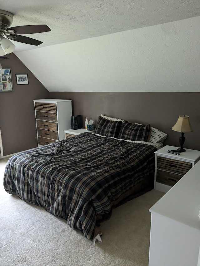 carpeted bedroom featuring a textured ceiling, ceiling fan, and lofted ceiling