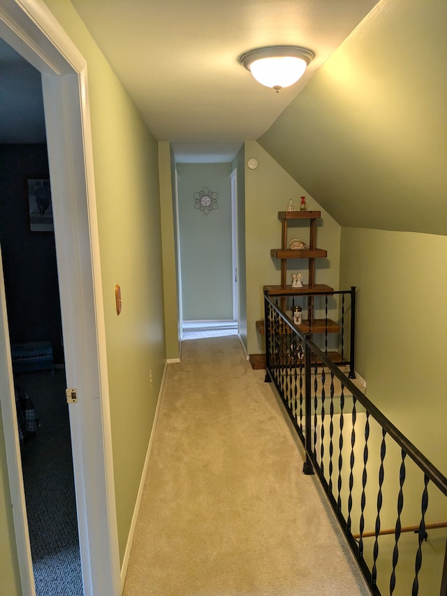 hallway featuring light carpet and vaulted ceiling