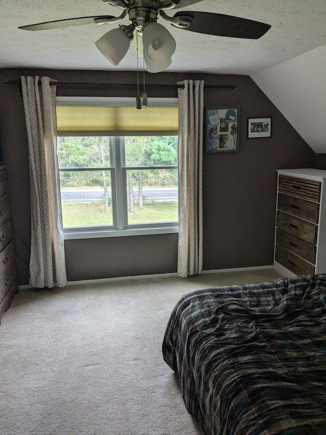 bedroom featuring carpet flooring, a textured ceiling, vaulted ceiling, and ceiling fan