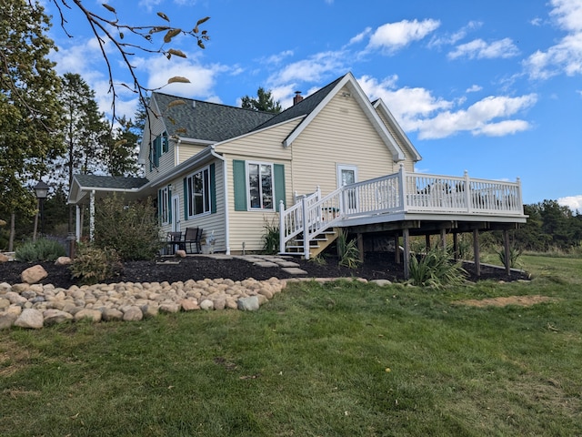 rear view of property with a yard and a deck