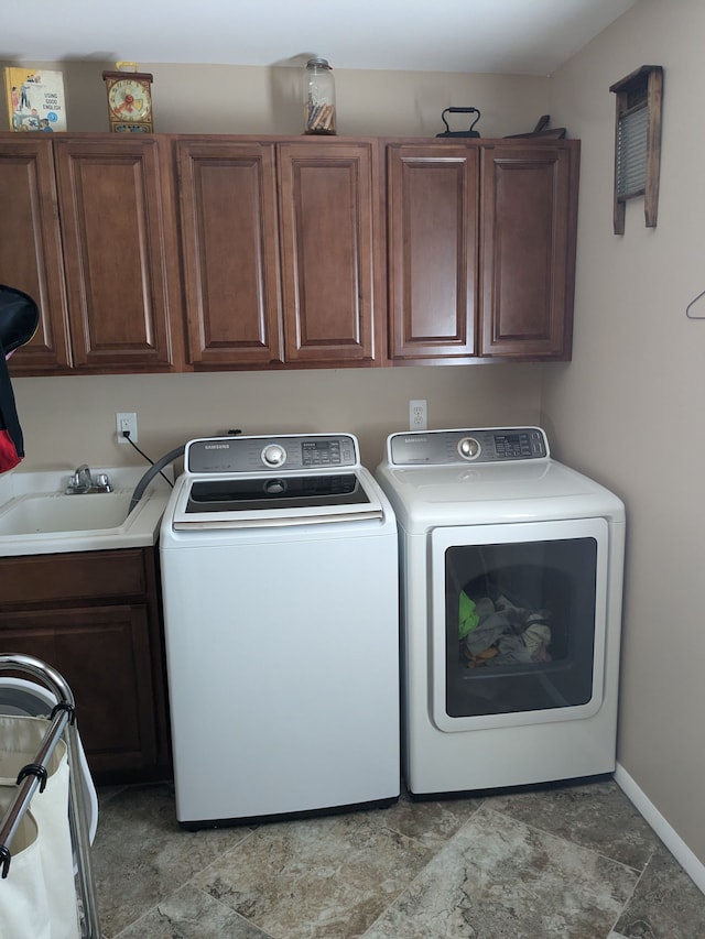 clothes washing area featuring cabinets, washer and dryer, and sink