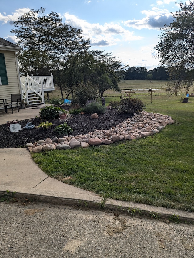 view of yard featuring a wooden deck and a rural view