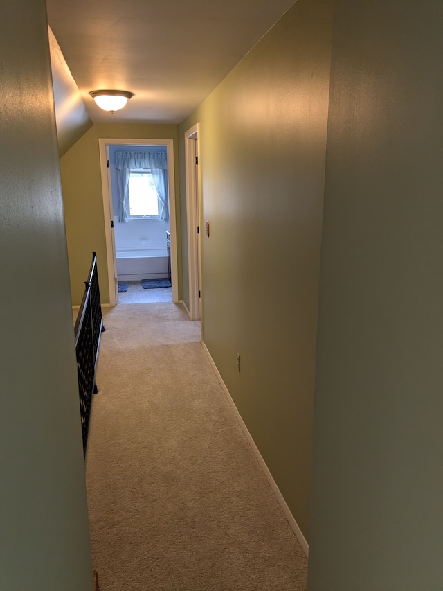 hall with light colored carpet and lofted ceiling