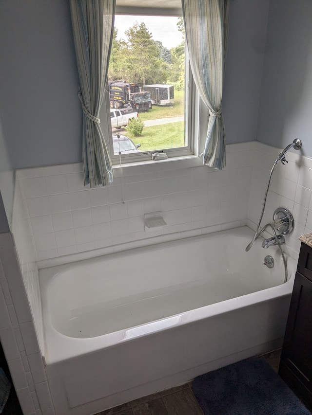 bathroom featuring vanity and a bath