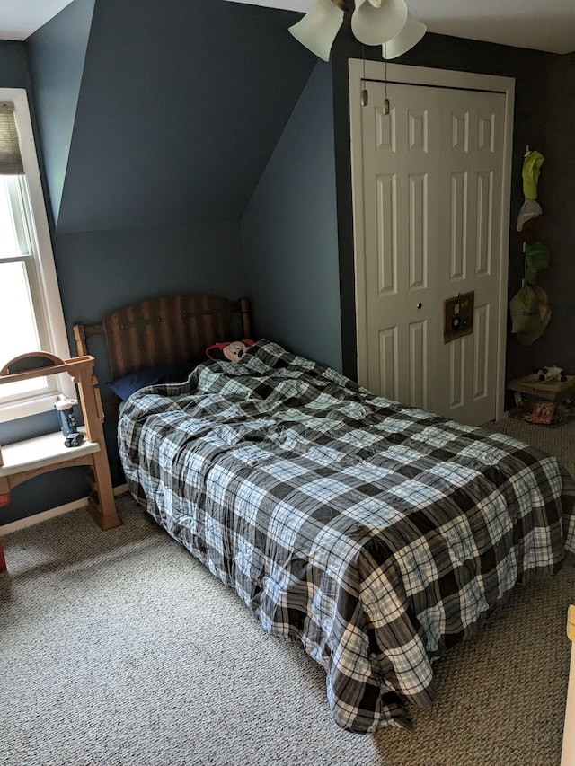 bedroom featuring carpet flooring, a closet, lofted ceiling, and ceiling fan