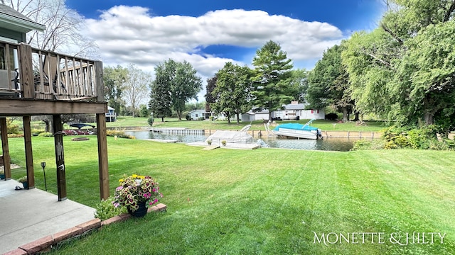 view of yard with a boat dock and a water view