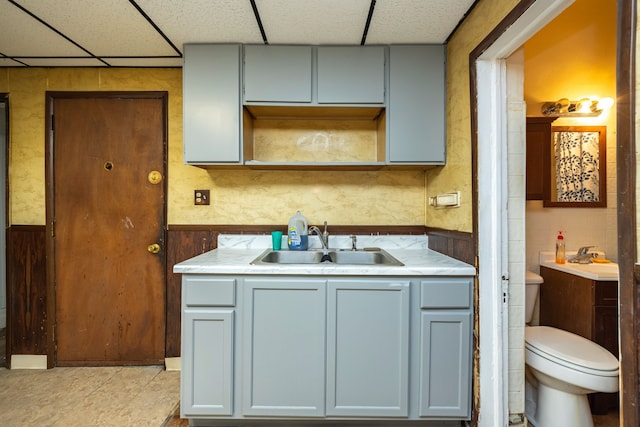 kitchen with a drop ceiling, light tile patterned floors, and sink