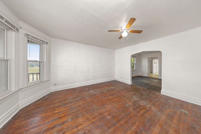 empty room with ceiling fan, dark hardwood / wood-style flooring, and ornamental molding