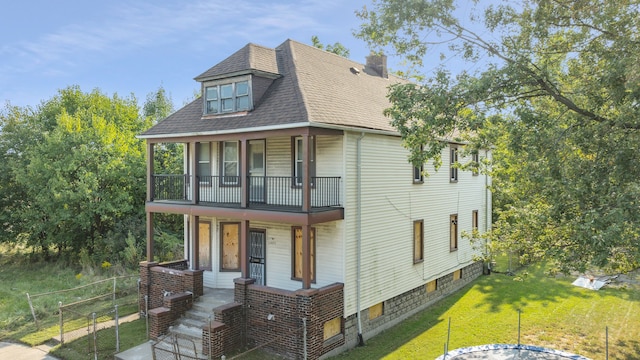 view of front of home featuring a porch, a balcony, and a front lawn