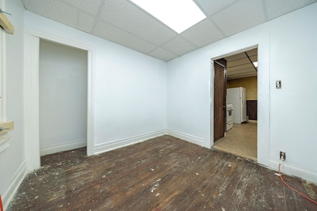 empty room with a drop ceiling and dark hardwood / wood-style floors