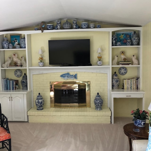 carpeted living room with a brick fireplace and vaulted ceiling