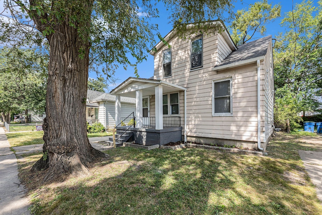 view of front of property featuring covered porch and a front lawn