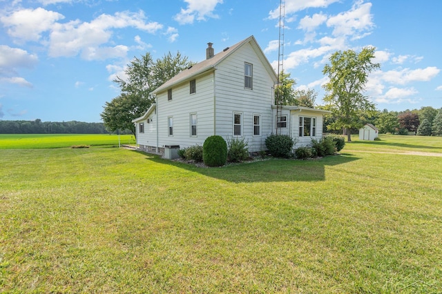 view of property exterior with a lawn, cooling unit, and a shed