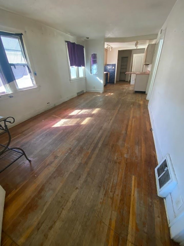 unfurnished living room with dark wood-type flooring