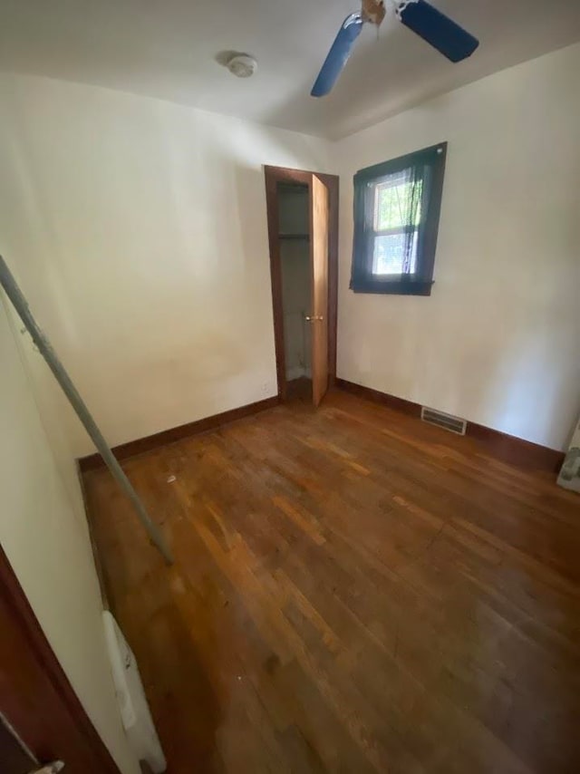 unfurnished bedroom with ceiling fan and dark hardwood / wood-style floors