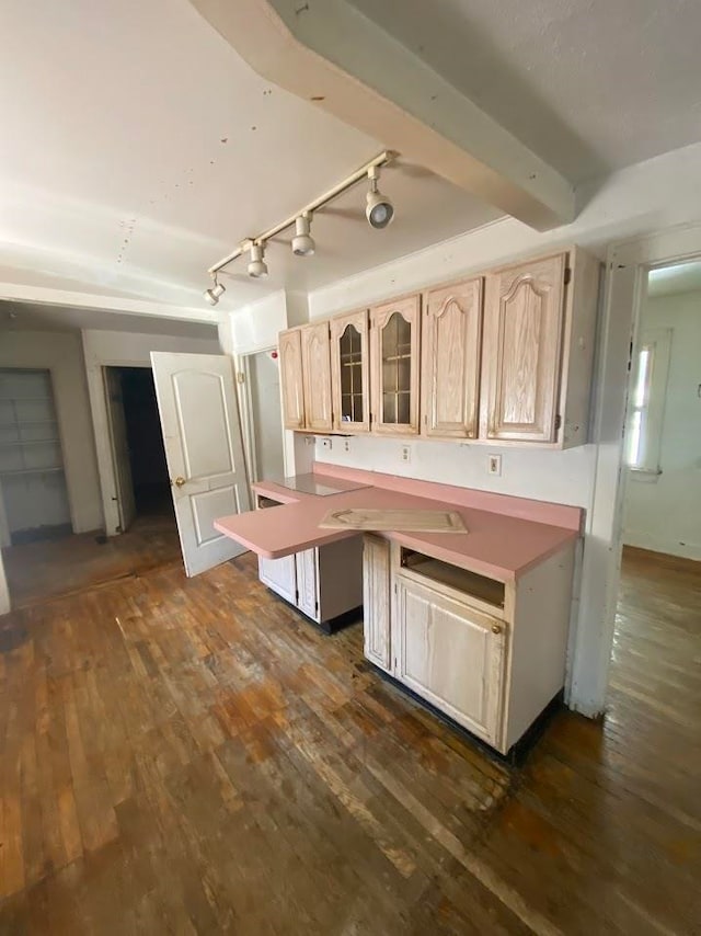 kitchen with light brown cabinetry, beamed ceiling, dark wood-type flooring, and rail lighting