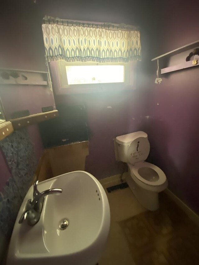 836 Victoria Ave, Flint, MI 48507 - half bath featuring a sink, toilet, and baseboards