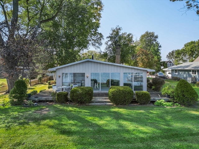 rear view of property featuring a lawn