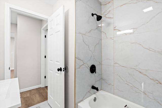 bathroom featuring vanity, hardwood / wood-style flooring, and tiled shower / bath