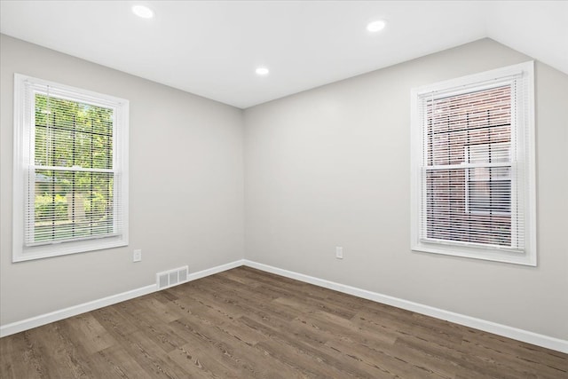 spare room featuring dark hardwood / wood-style flooring and vaulted ceiling